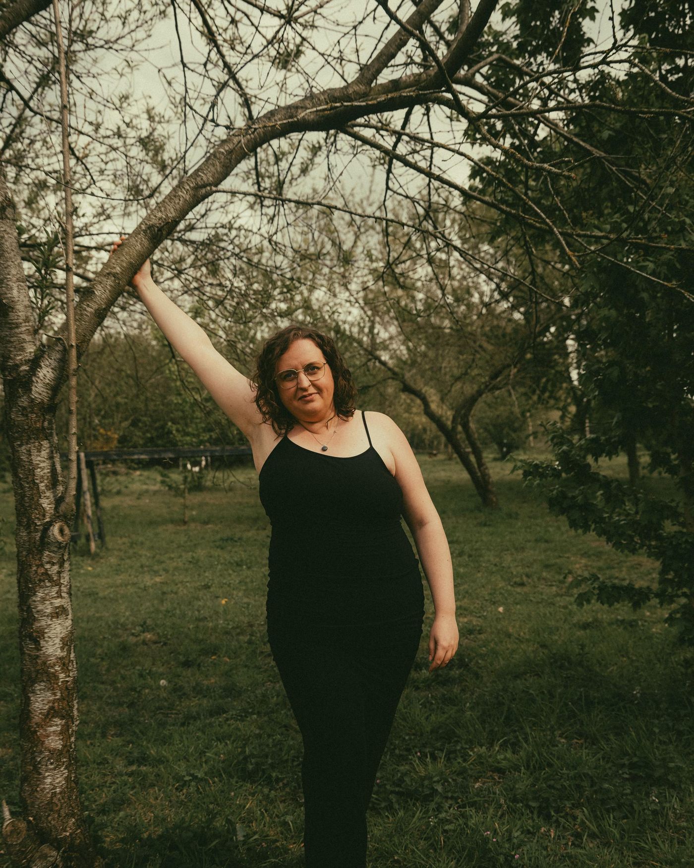 Florette Vervloet staat in een boomgaard met haar hand aan een tak